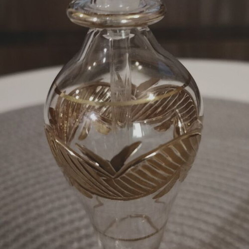 Glass perfume bottle used with golden accents and cap