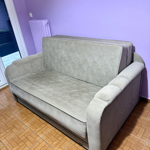 Two-seater sofa light brown/grey like new, folds into a bed