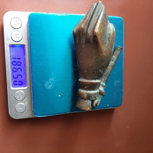 Antique bronze door knocker in hand shape