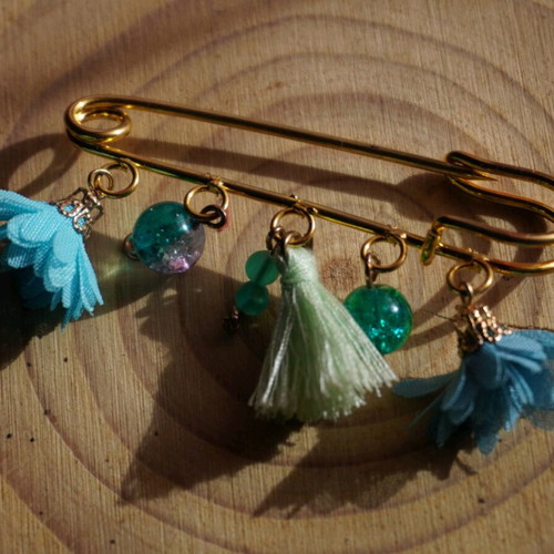 Handmade brooch with dangling elements in light blue and turquoise