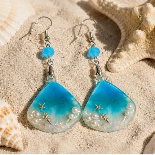 Handmade earrings with stars, shells, pearls, and crystals in resin