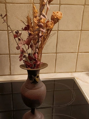 Vintage vase used made of cast iron with dried flowers