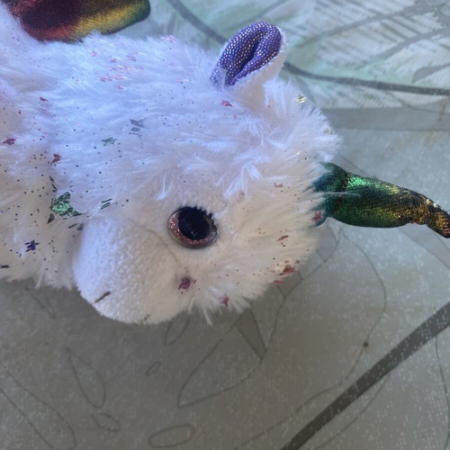 Unicorn plush toy with colorful shiny wings and metallic purple details