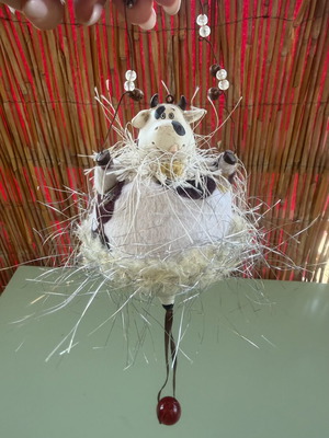 Hanging decorative ornament with fabric and ceramic cow