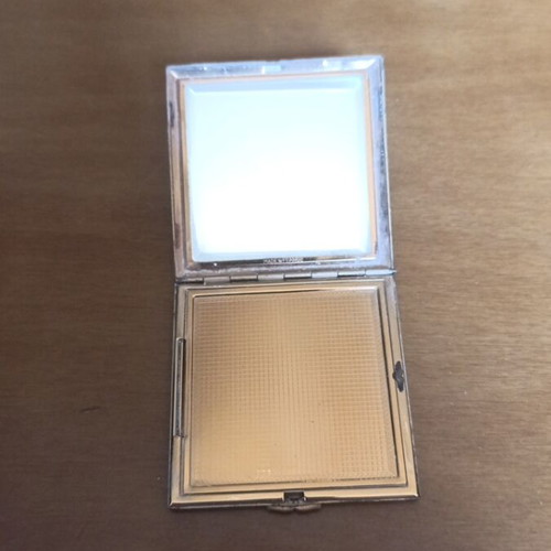 Compact powder with mirror used, black and gold design