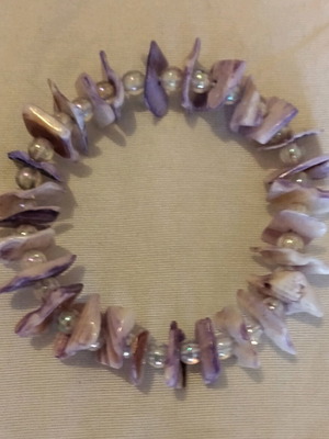 Elastic bracelet new with purple artificial shell fragments and cream beads