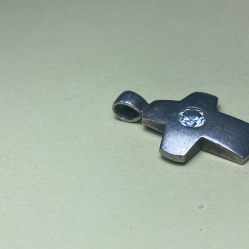 Silver cross used with stone