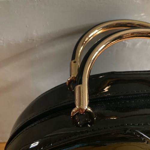 Round black glossy handbag like new with gold handles