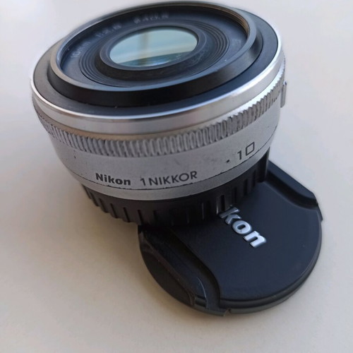 Nikon 1 NIKKOR 10mm f/2.8 lens used, silver compact prime