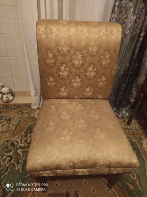 Antique armchair used with golden upholstery and carved legs