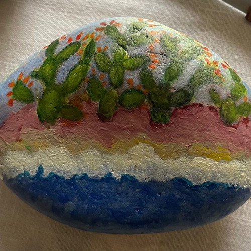 Large painted pebble with prickly pears on the seashore