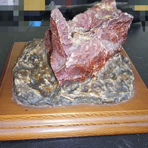 Decorative used piece with red mineral stone on wooden base