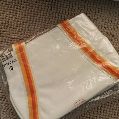 Clarins cosmetic bag new, white with striped handles