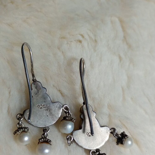 Silver earrings used with purple stones and pearls