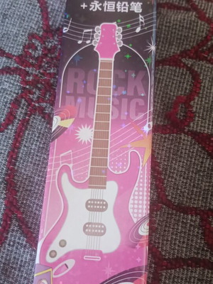 Pink guitar-shaped pen with musical notes
