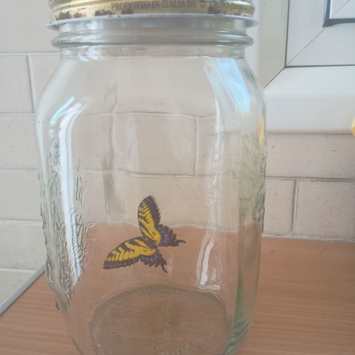 Decorative jar with moving butterfly mechanism