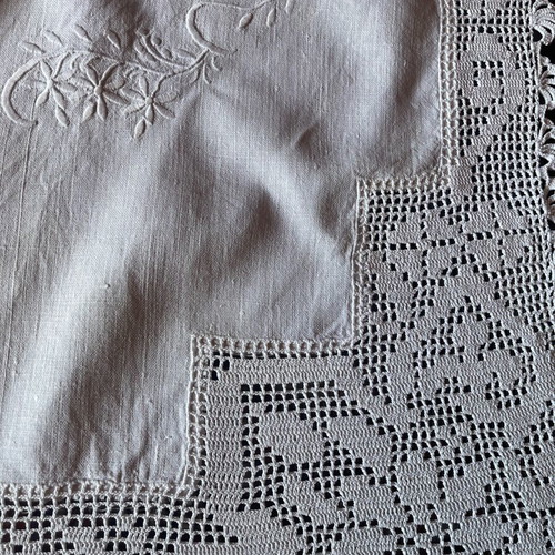 White embroidered tablecloth used on linen fabric with lace