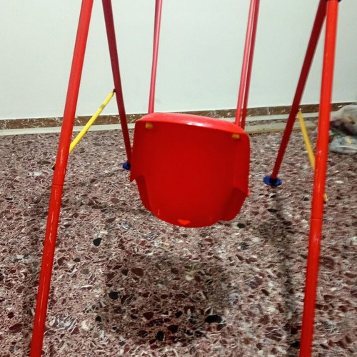 Child swing with metal frame and plastic seat, used with plastic wear