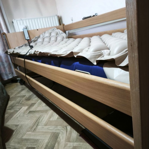 Electric hospital bed with wooden frame, pressure relief mattress and pump