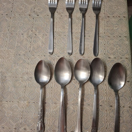 Cutlery set used, includes plates, forks, spoons, glasses, coffee cups