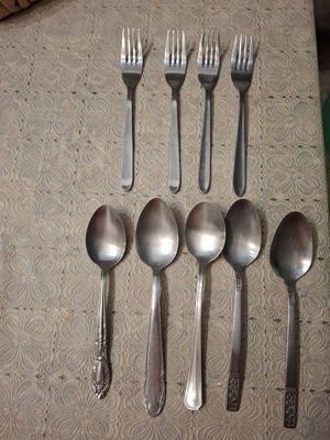 Cutlery set used, includes plates, forks, spoons, glasses, coffee cups