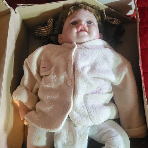 Vintage collectible baby doll with porcelain head and glass eyes