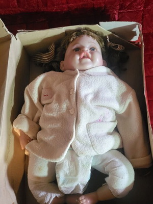 Vintage collectible baby doll with porcelain head and glass eyes