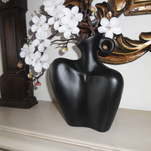 White orchid and black plastic vase shaped like female bust