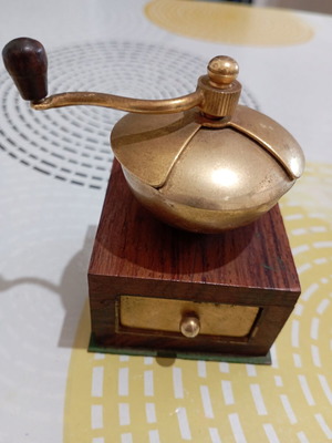 Vintage miniature manual coffee grinder with wooden body and brass hopper