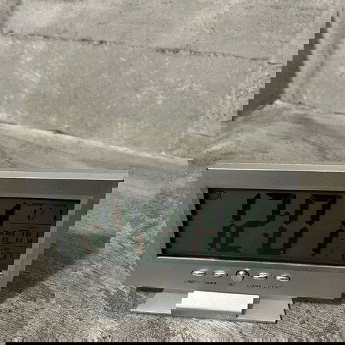 Digital table clock used with alarm and thermometer