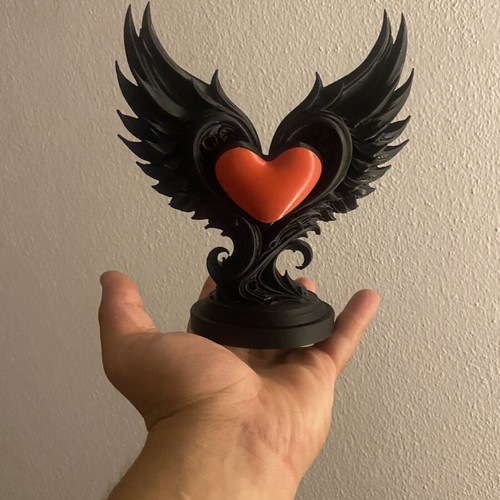 Decorative sculpture with black wings and red heart, new