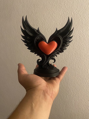 Decorative sculpture with black wings and red heart, new