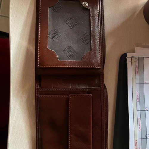 Brown wallet used with multiple card slots and belt-style clasp