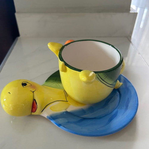 Vintage ceramic children's mug with turtle design used