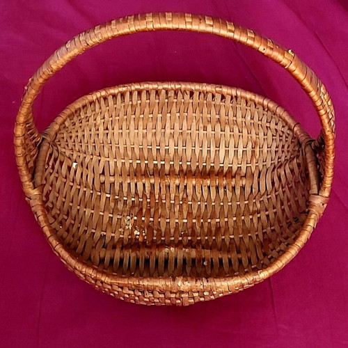 Woven straw basket used with red satin ribbon