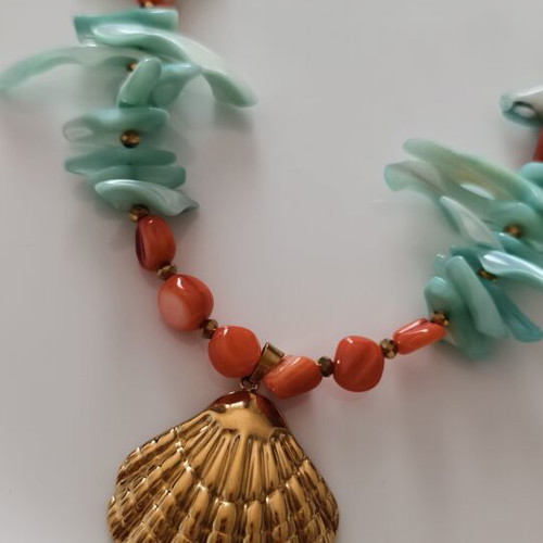 Necklace with shell chips and steel clam pendant