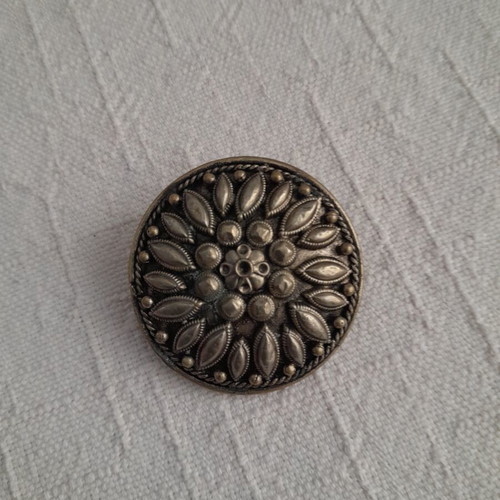 Vintage round metal brooch with embossed floral design like new