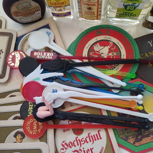 Vintage bar collection with mini liquor bottles, coasters, and stirrers