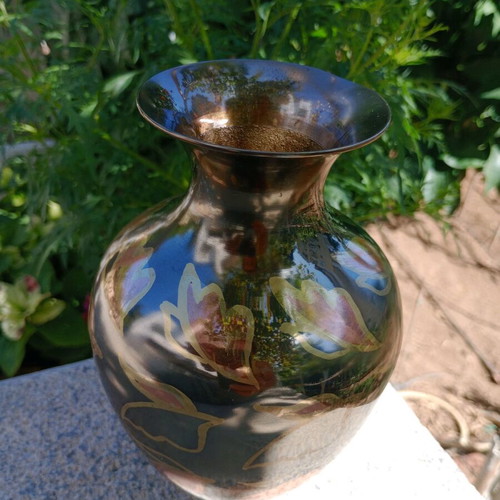 Intricately enameled brass vase with flowers.