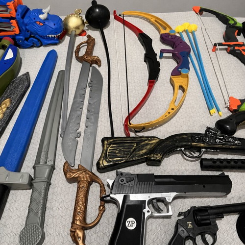 Children's toy weapons set including nerf guns, swords, bows, and truck race track
