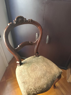 Classic wooden vintage chair with carved back and fabric seat