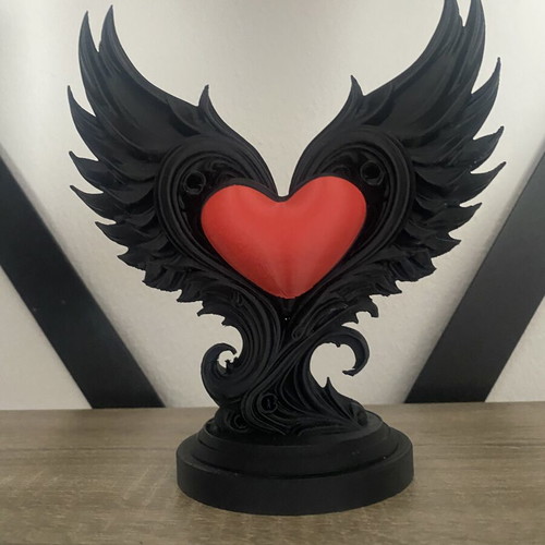 Decorative sculpture with black wings and red heart, new