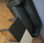 Black leather three-seater sofa used with coffee tables