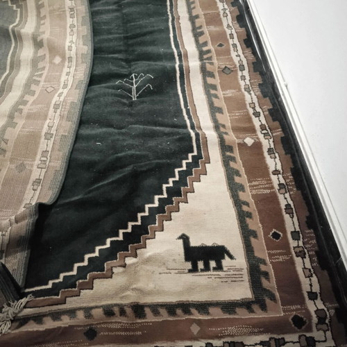 Turquoise machine-made rug used with animal and human designs