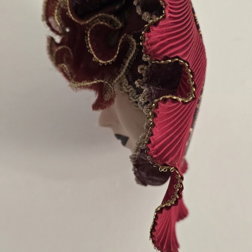 Decorative porcelain wall mask used with fabric hat in burgundy