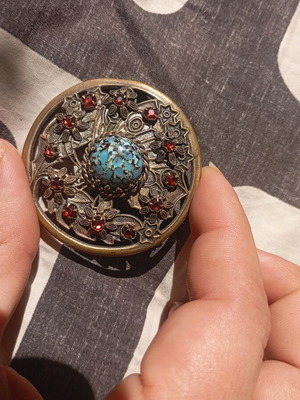 Vintage round brooch with turquoise matrix stone and red crystals