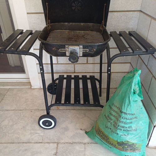 Charcoal grill used, wheeled with shelves and tools