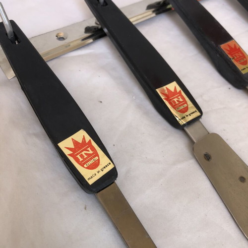Vintage stainless steel kitchen tool set with black handles and wall rack