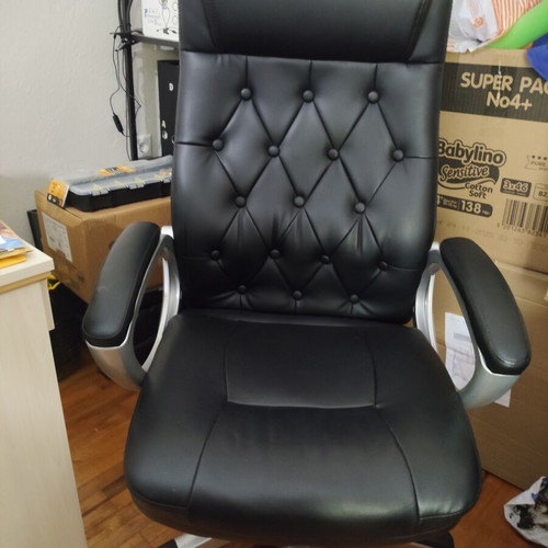 Office chair with black faux leather upholstery and button-tufted back