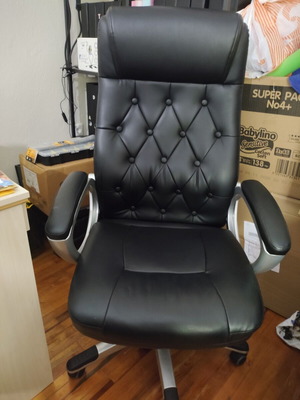 Office chair with black faux leather upholstery and button-tufted back